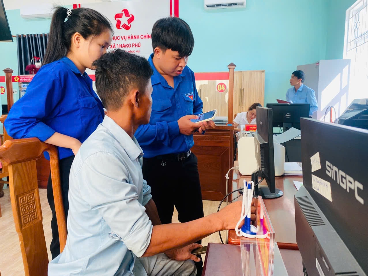 Đoàn viên thanh niên xã Thăng Phú hỗ trợ người dân thực hiện TTHC tại Trung tâm Phục vụ hành chính công xã. Ảnh: TRUNG THỰC
